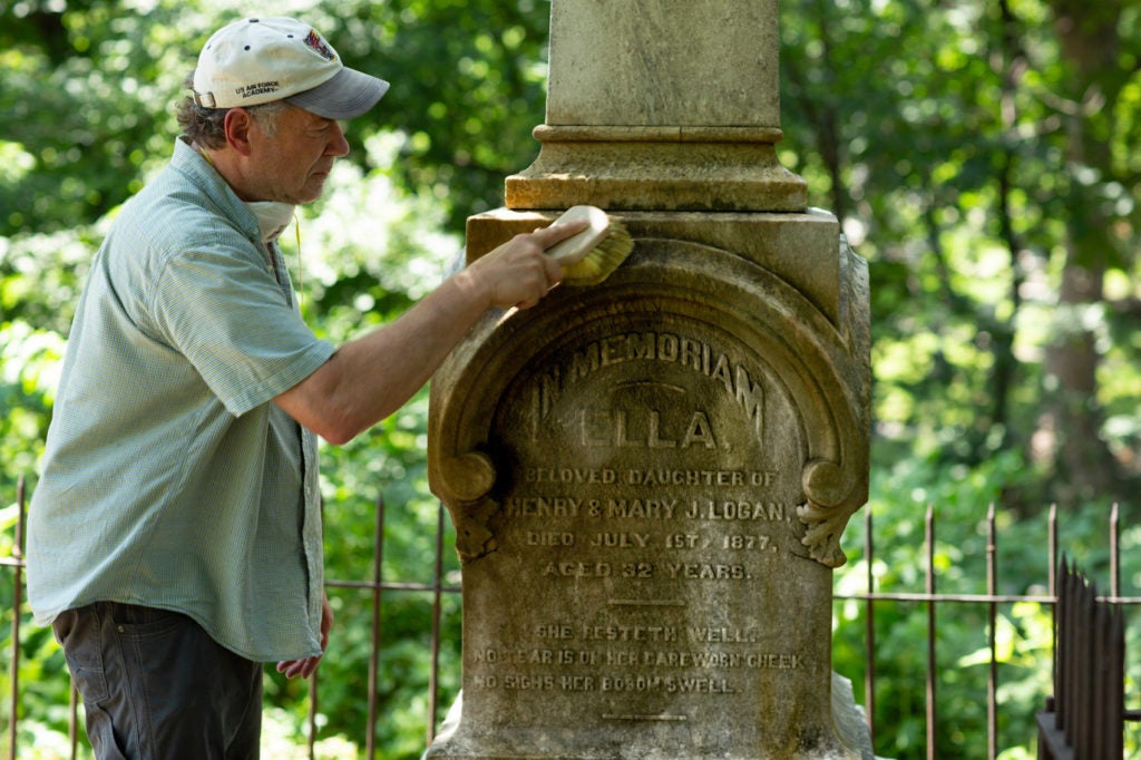 Man cleaning a gravestone