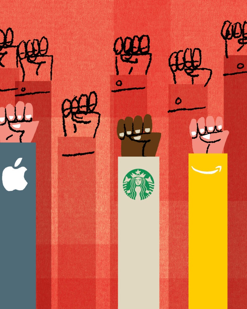 On a vivid orange background eleven arms are raised with clenched fists with the symbols of various corporate entities in their sleeves.