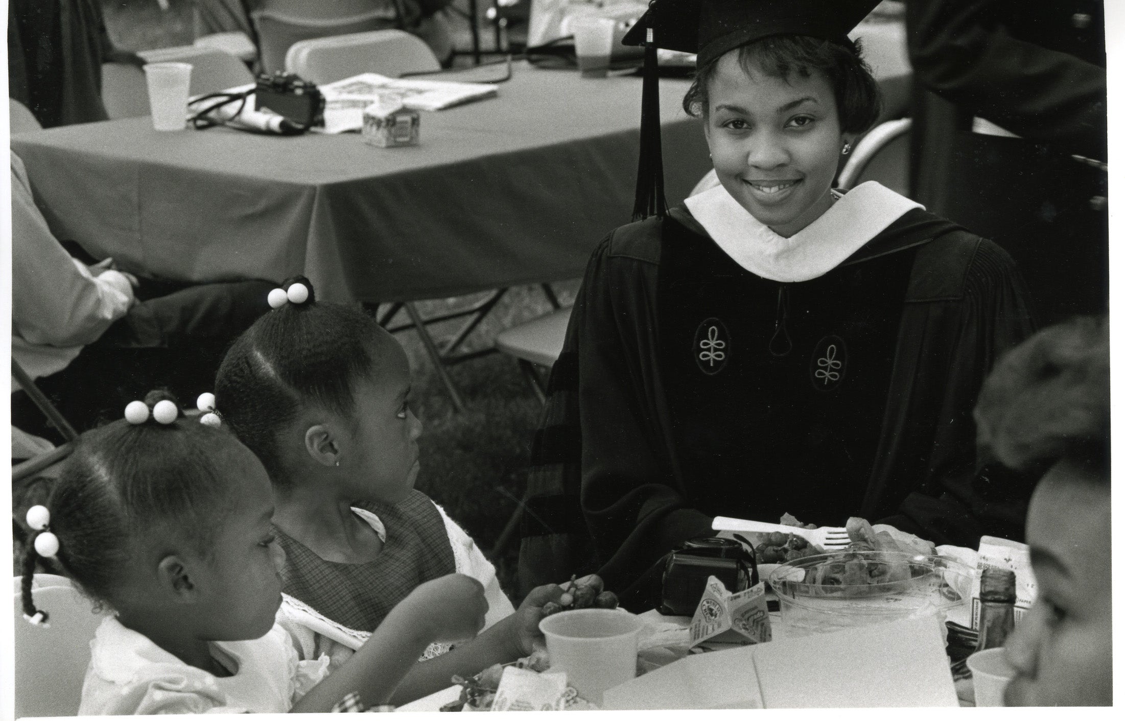 1989 graduate sits with two children
