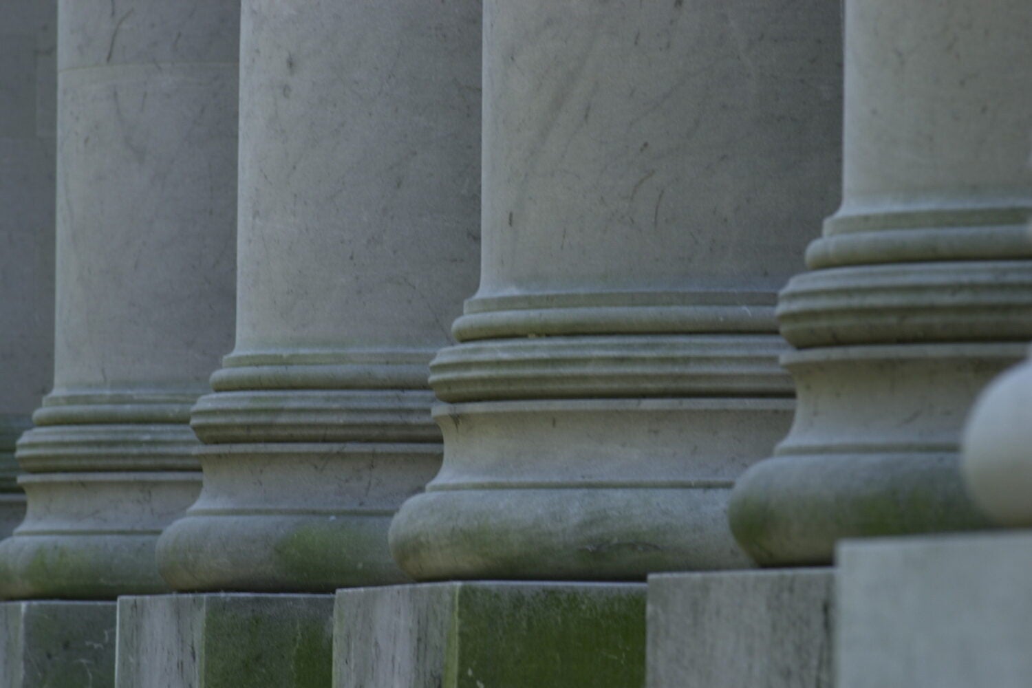 A detail of the bottom of 4 columns on a campus building