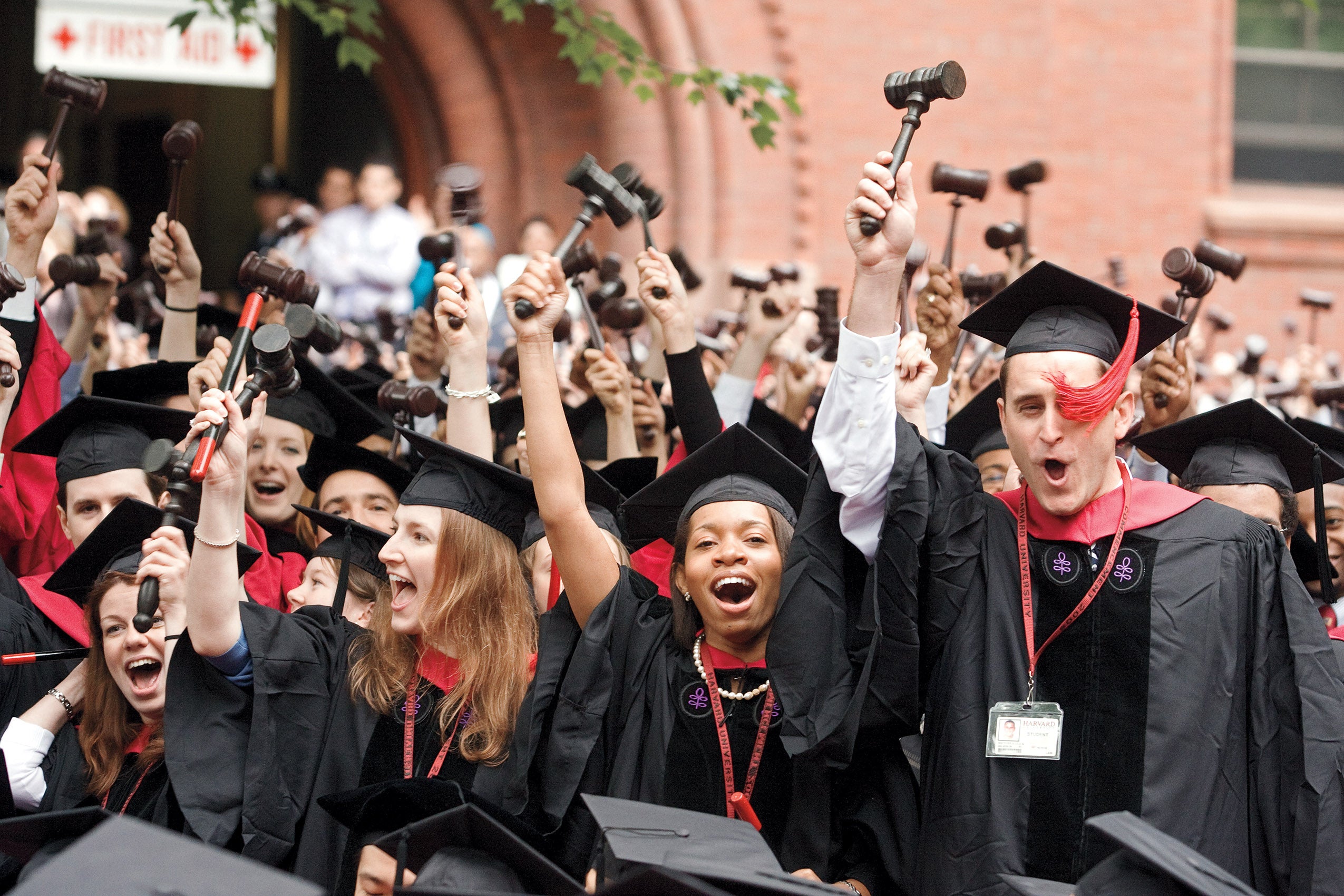 Harvard Law School graduates raise gavels as they celebrate the awarding of their degrees.