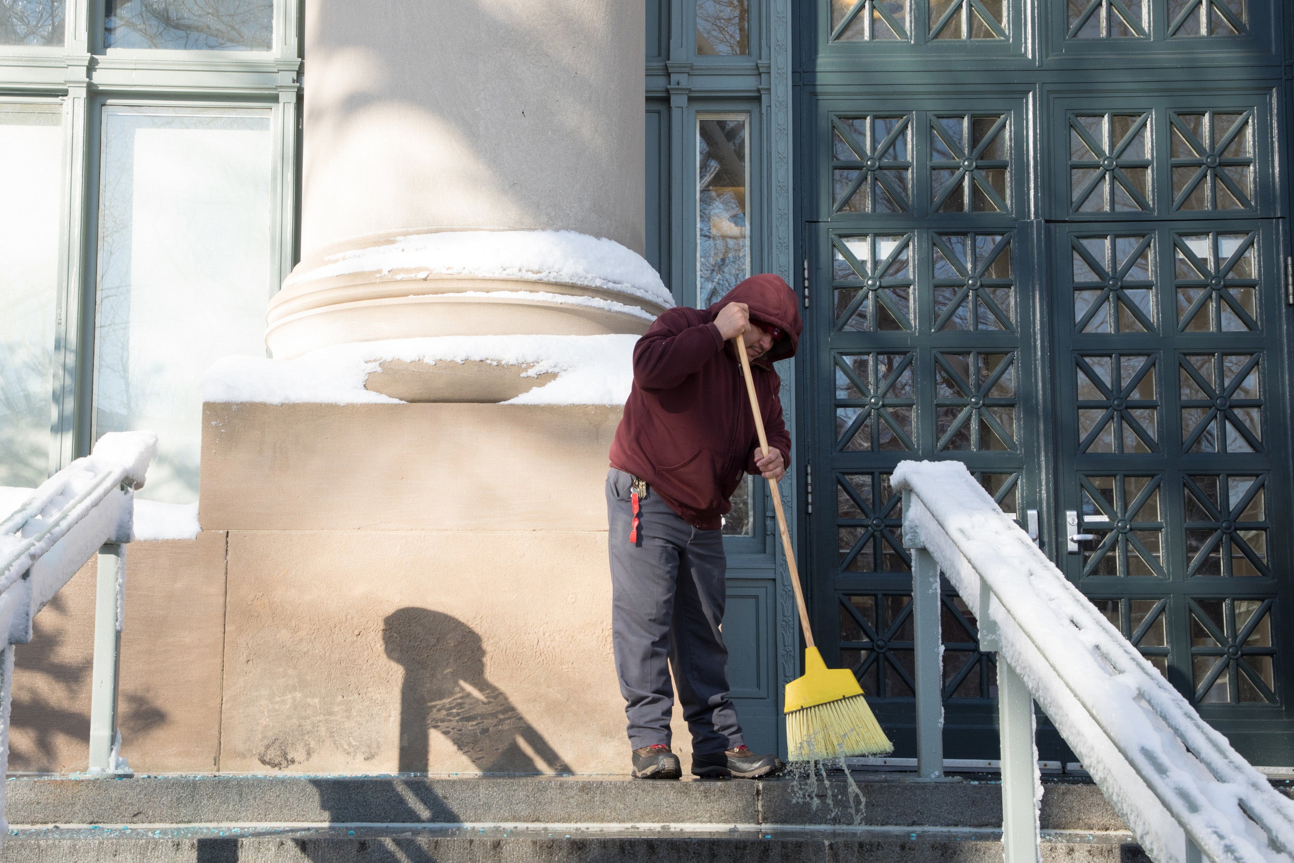 someone sweeping snow off steps