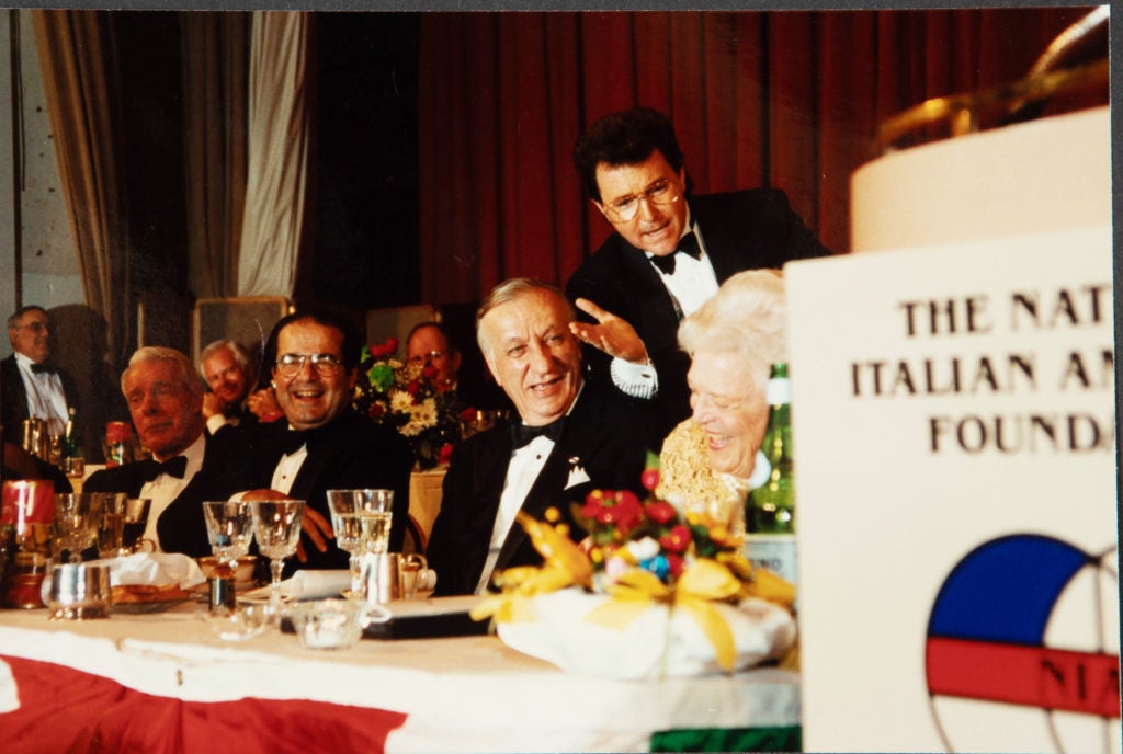 A group of people including Antonin Scalia at the head table of a black tie event