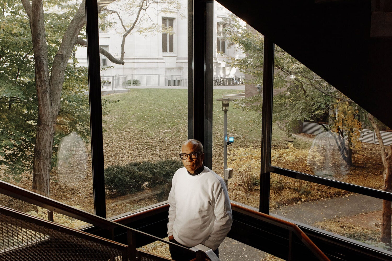 Randall Kennedy standing on a staircase surrounded by windows.