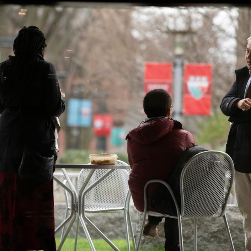 Student sitting outside the WCC with HLS banners in the background