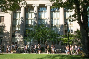 Students walk along a path outside Langdell Hall in the summer.