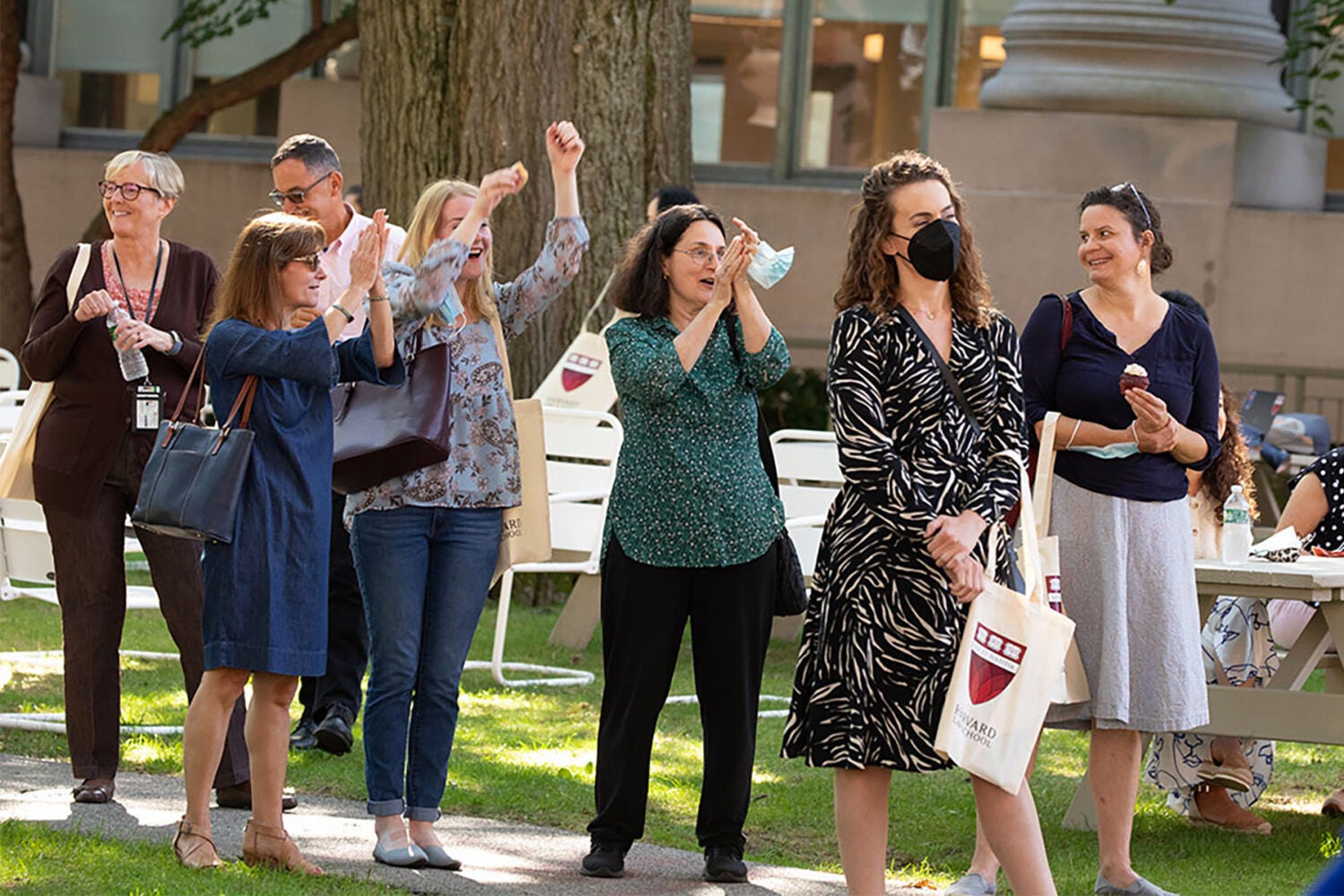 Group of women standing outside, three cheering.