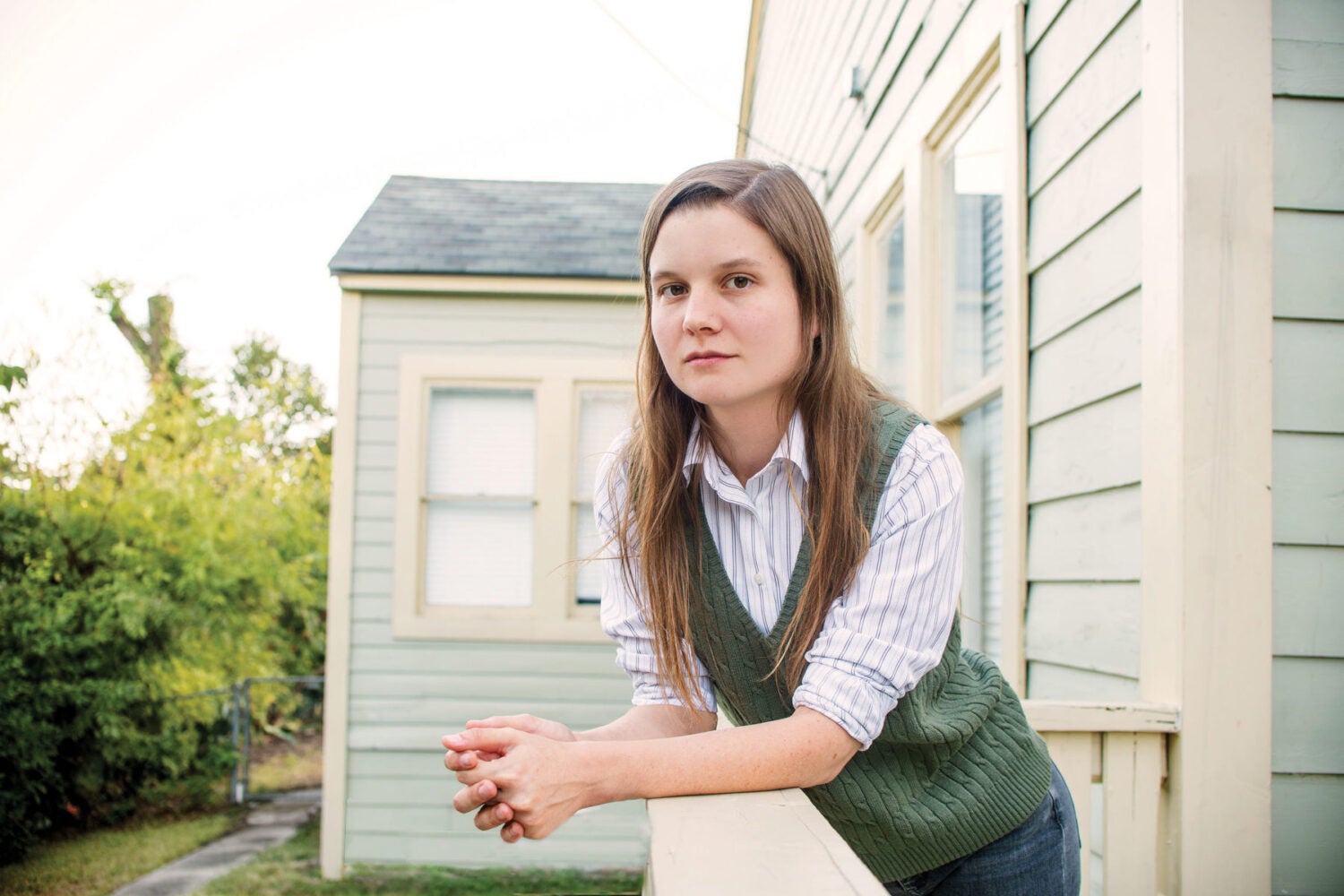 Brianna Rennix leaning on a railing outside a home