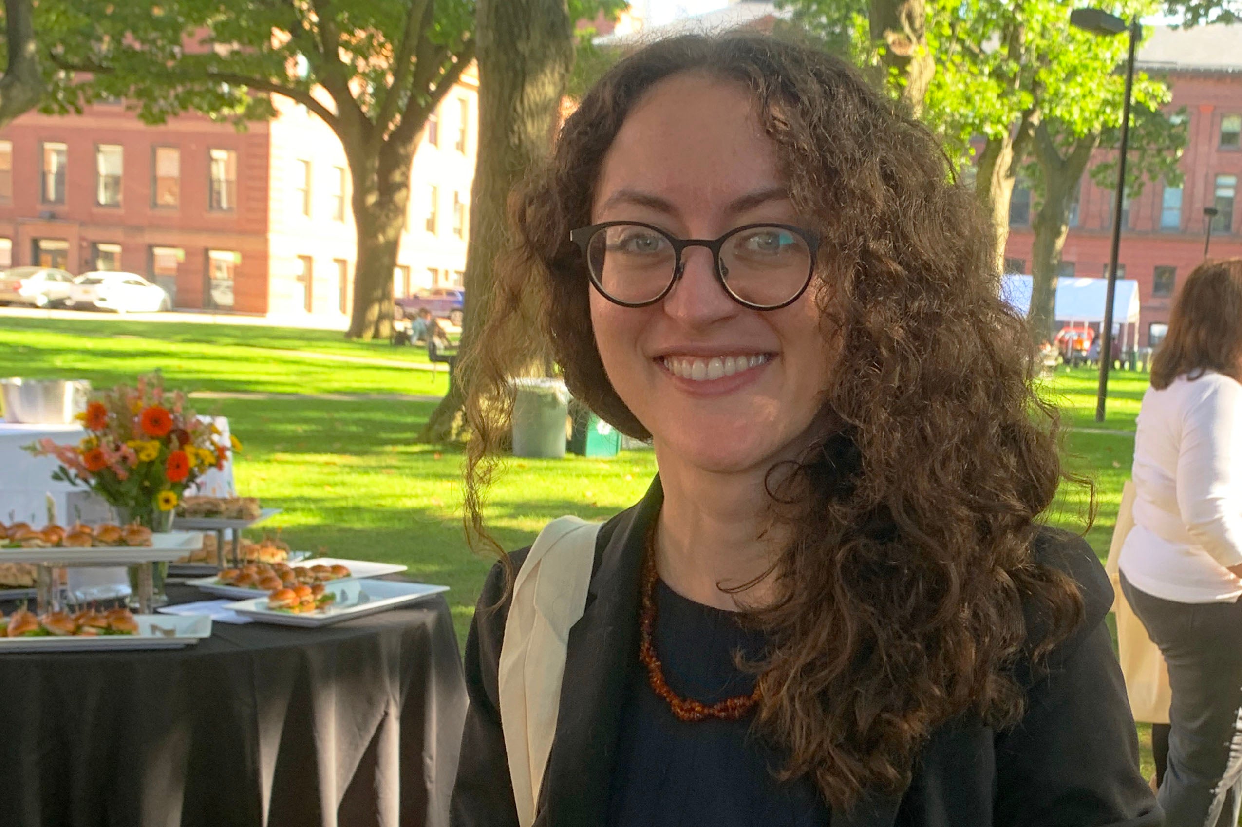 Woman wearing glasses outside smiling.