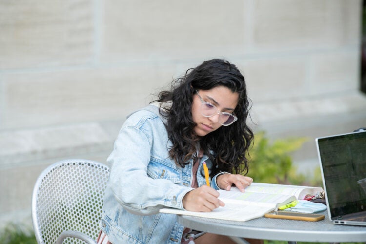 student studying at a table outside