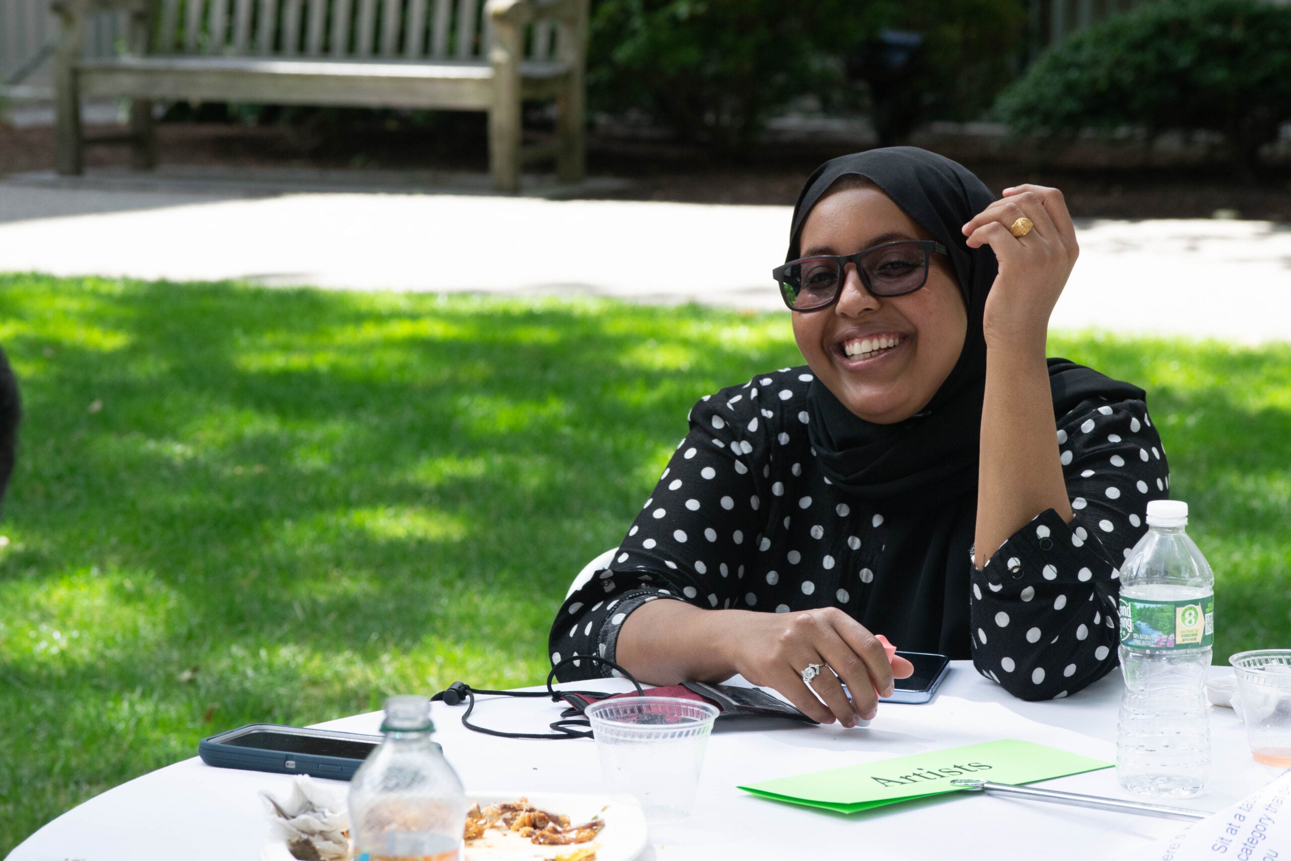 a woman sitting at a table outside.