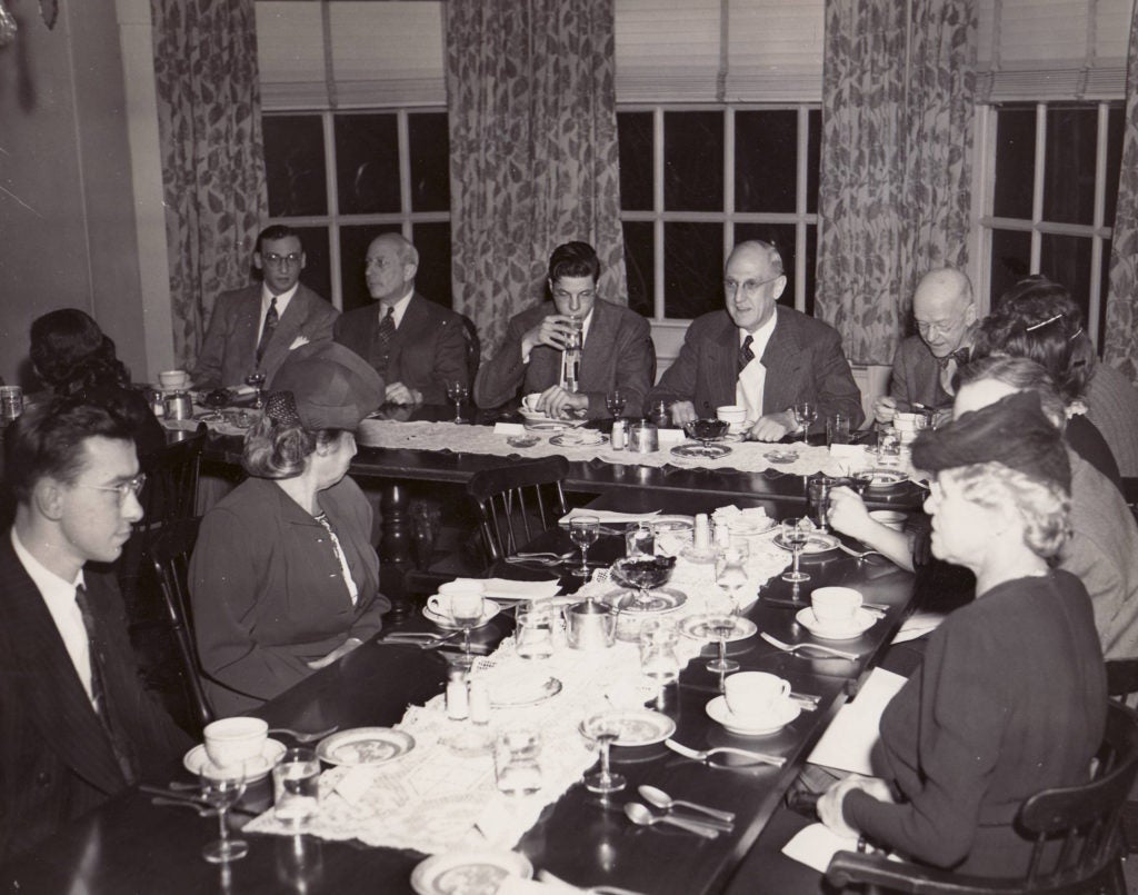 historic photo of group of people eating