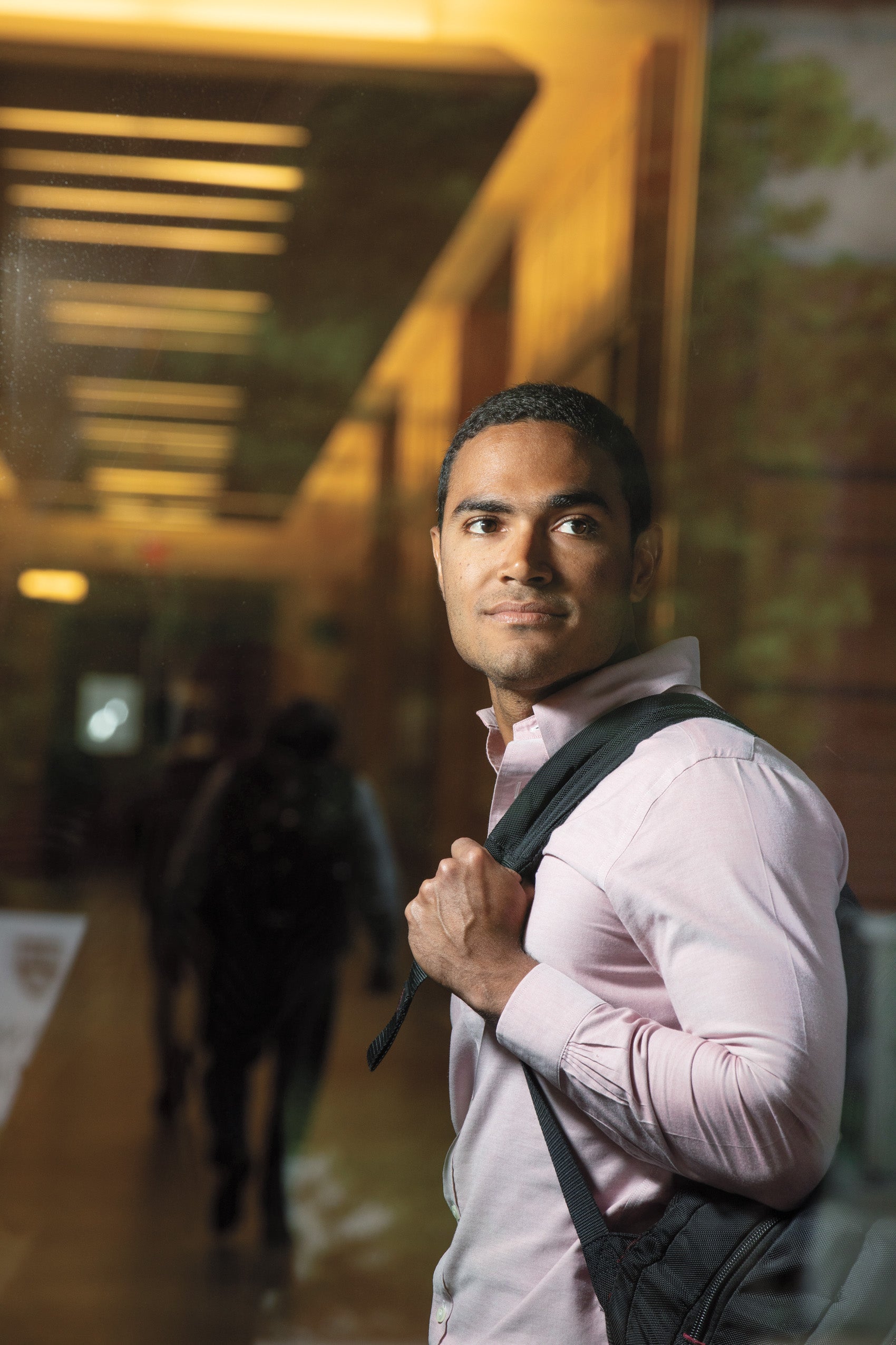 student looking at the camera holding a backpack