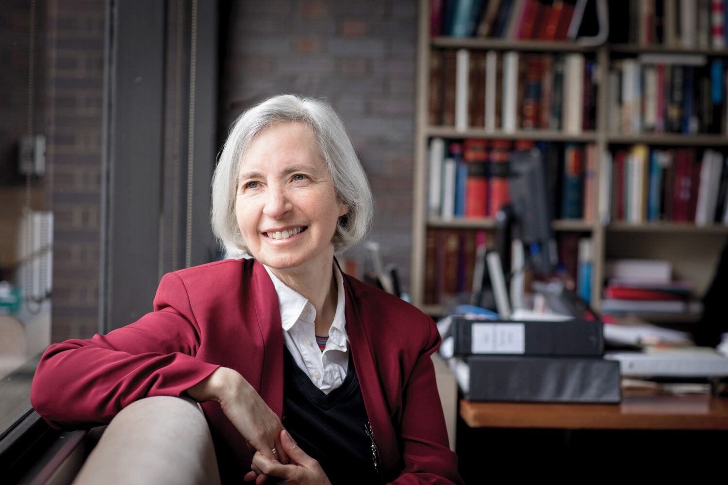 Martha Minow seated by a window in her office.