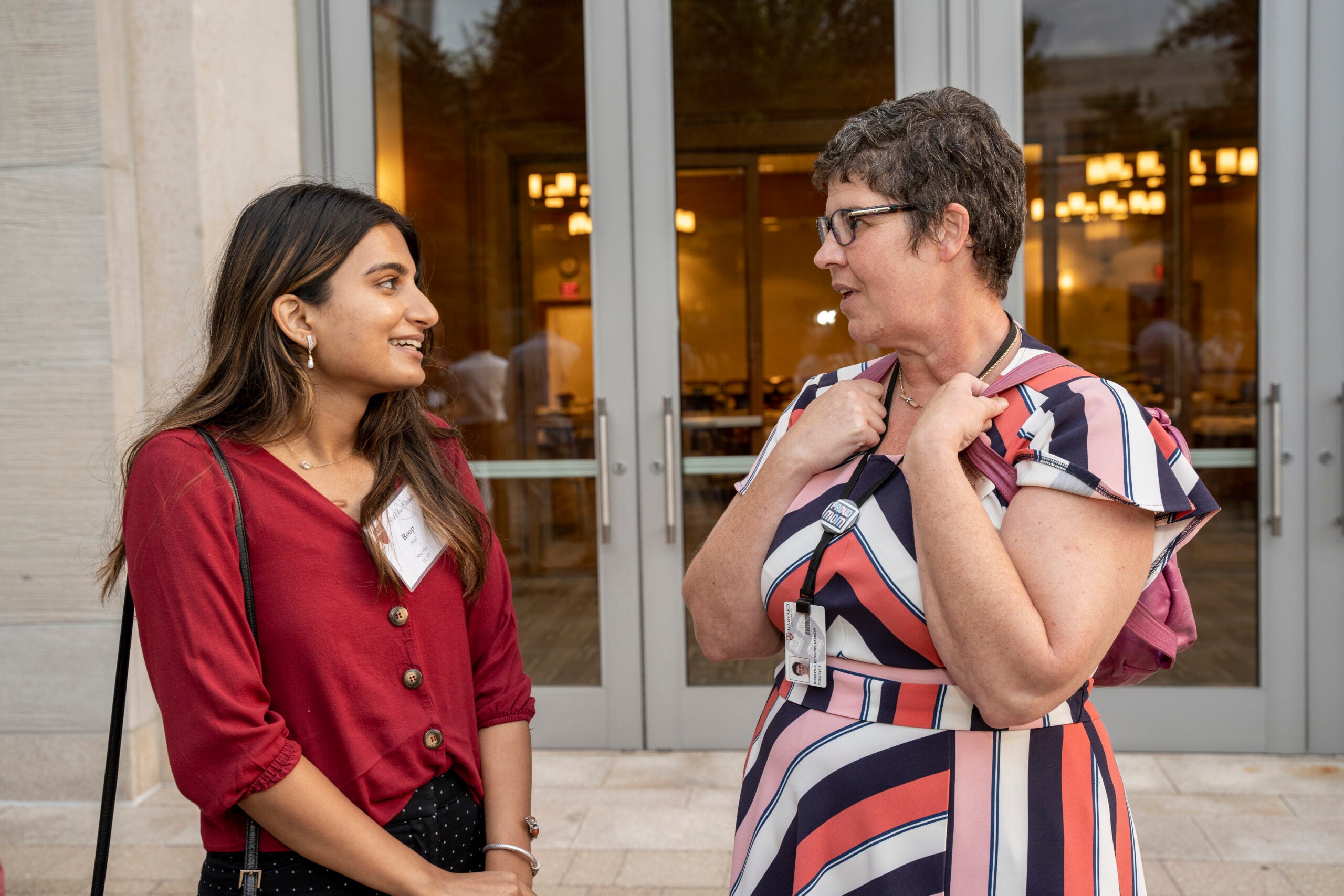 Two women standing outside talking.