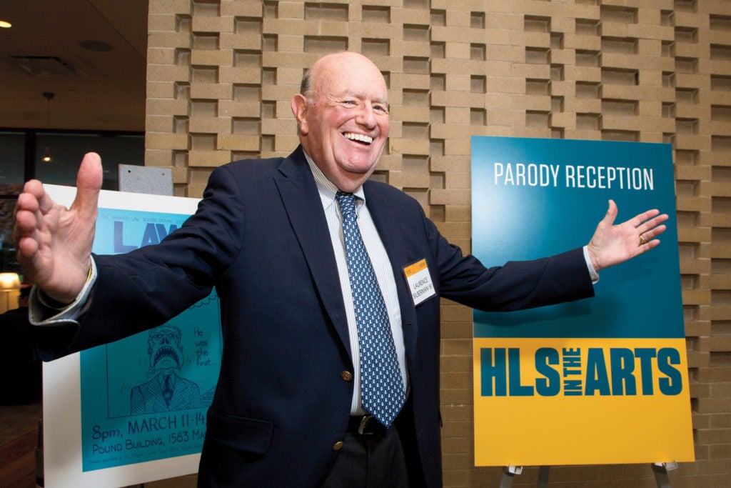 a man stands in front of a textured wall with his hands outstretched and a smile