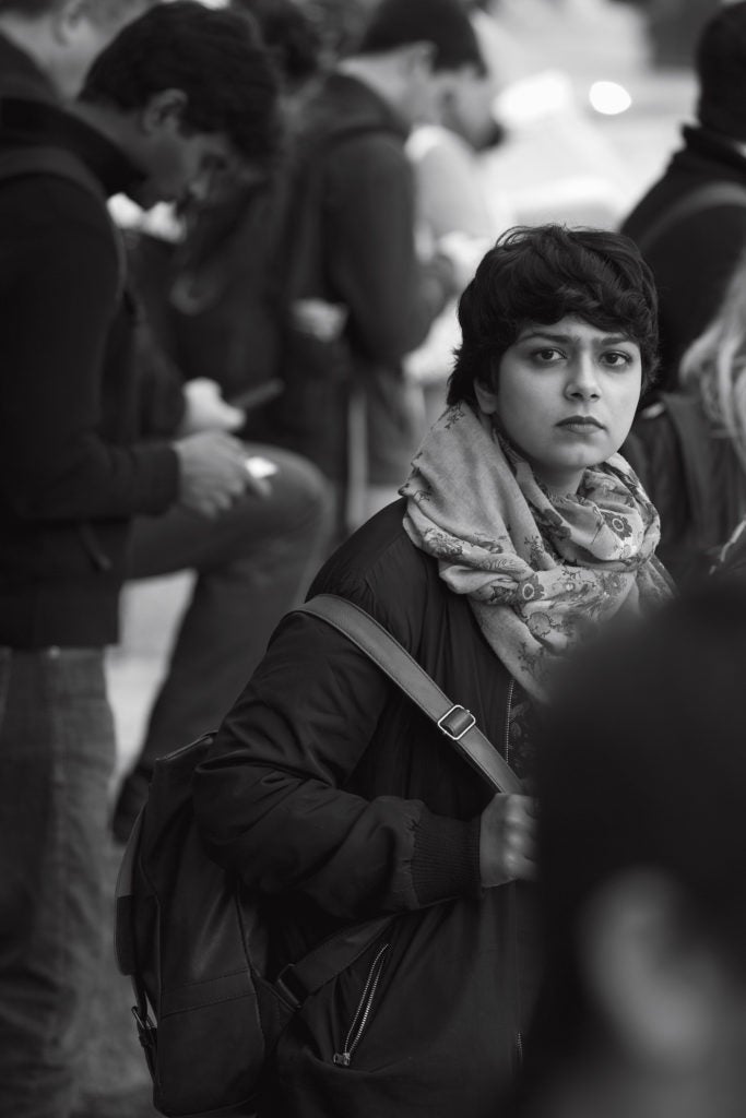 A woman looks out from a crowd as she is walking