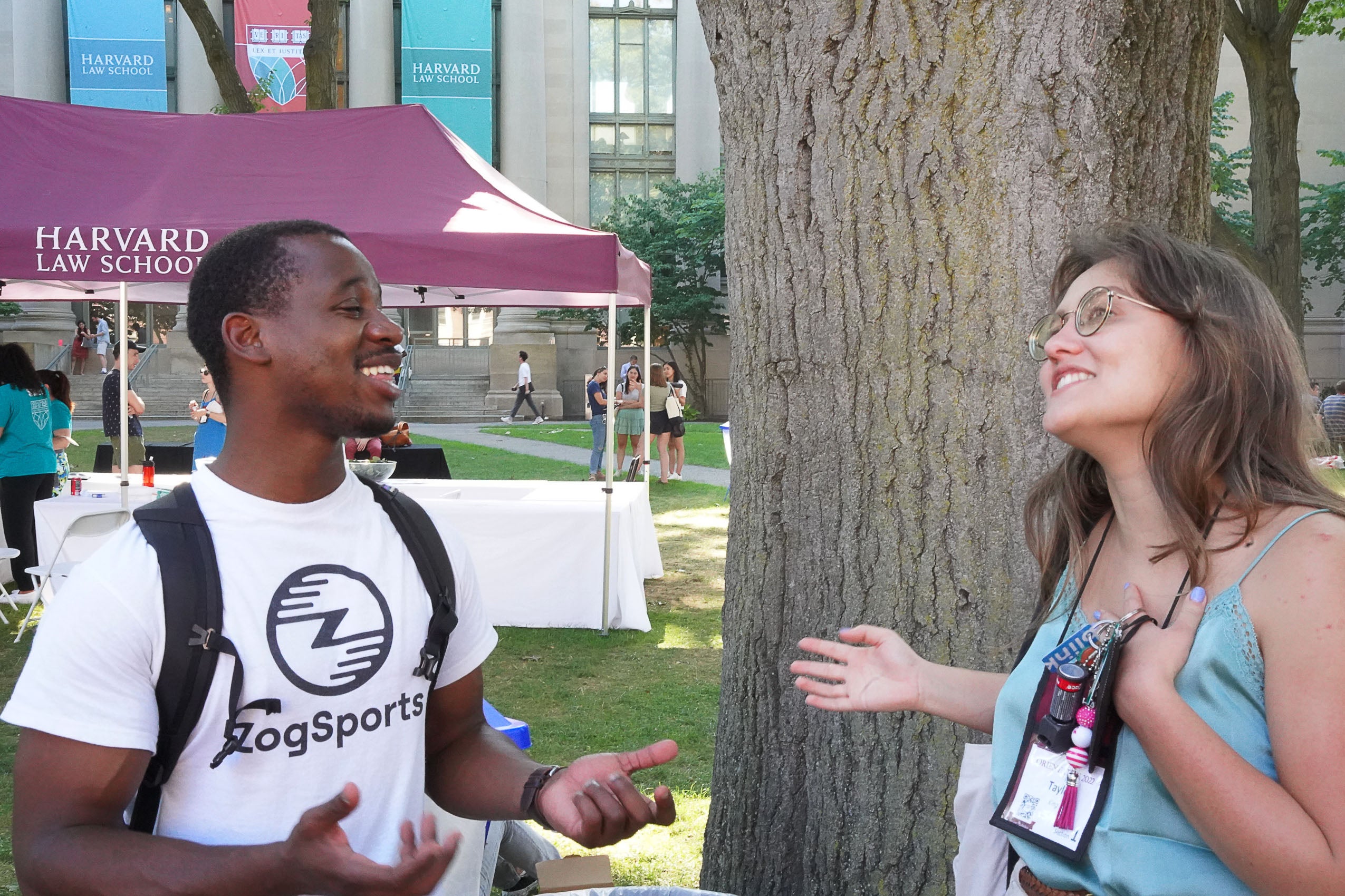 Two students standing outside talking and smiling.