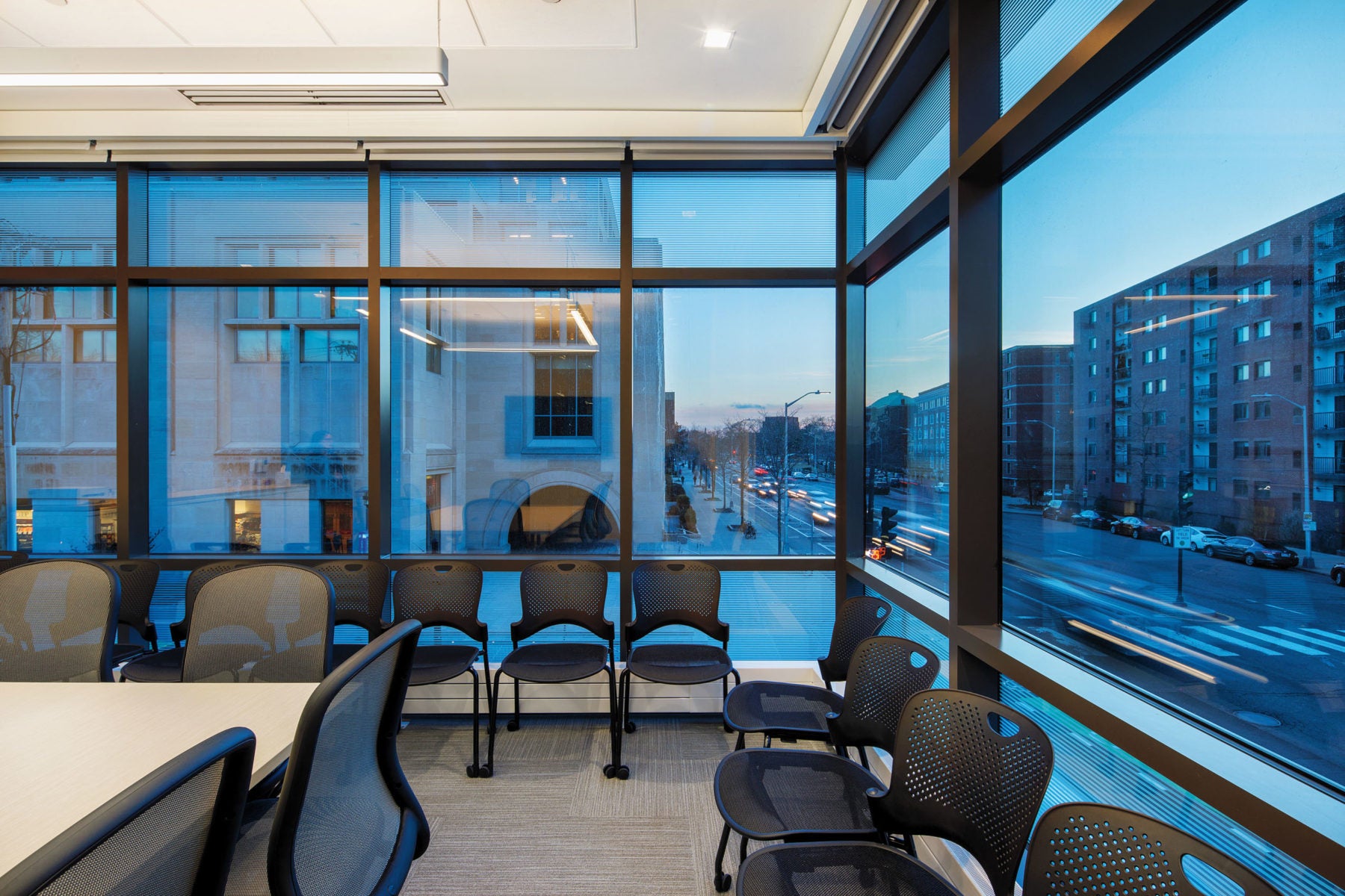 A corner conference room with all glass sides looking out to a busy street