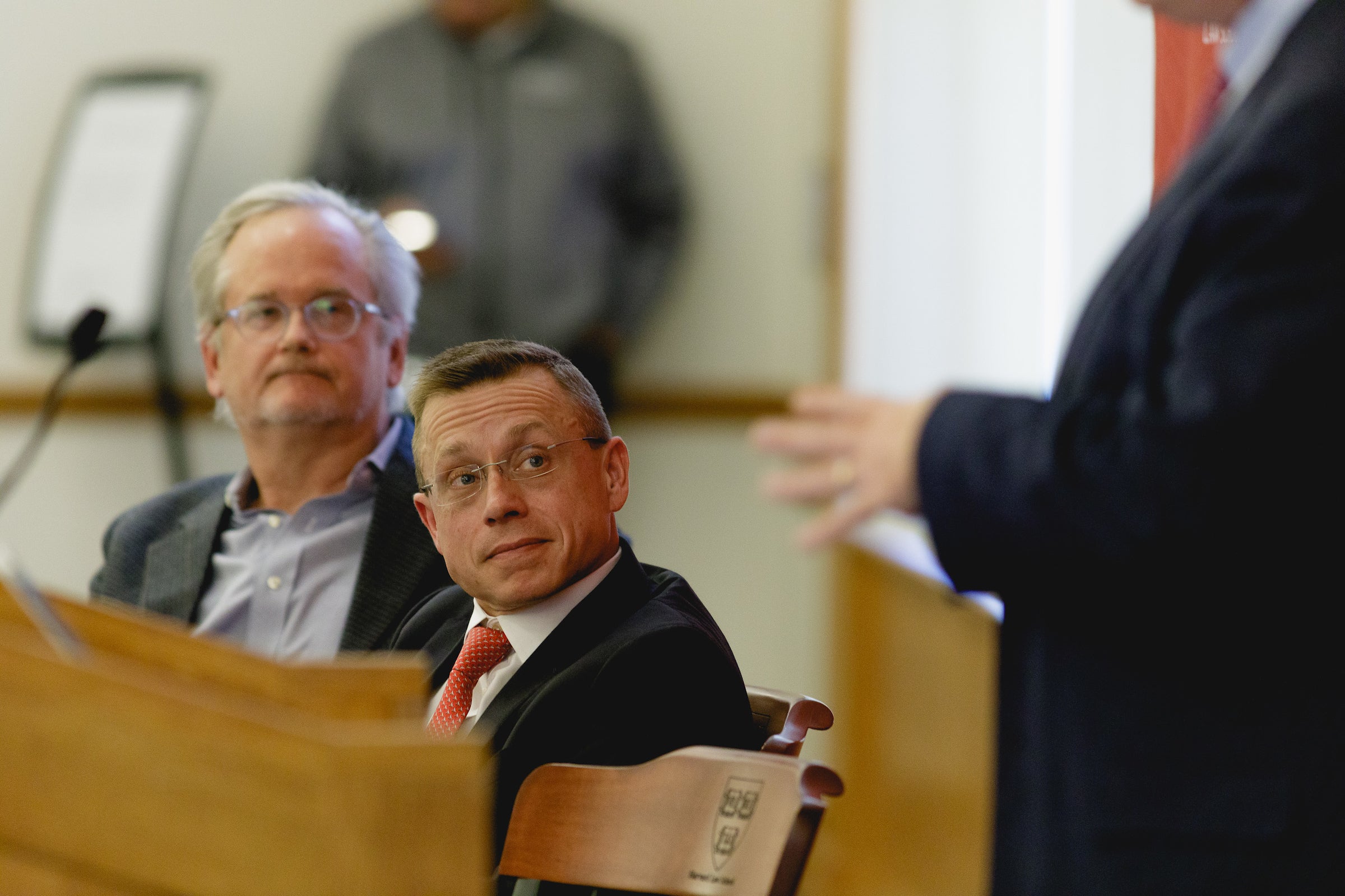 Lawrence Lessig and Andrew Oldham listen to Adrian Vermeule speaking.