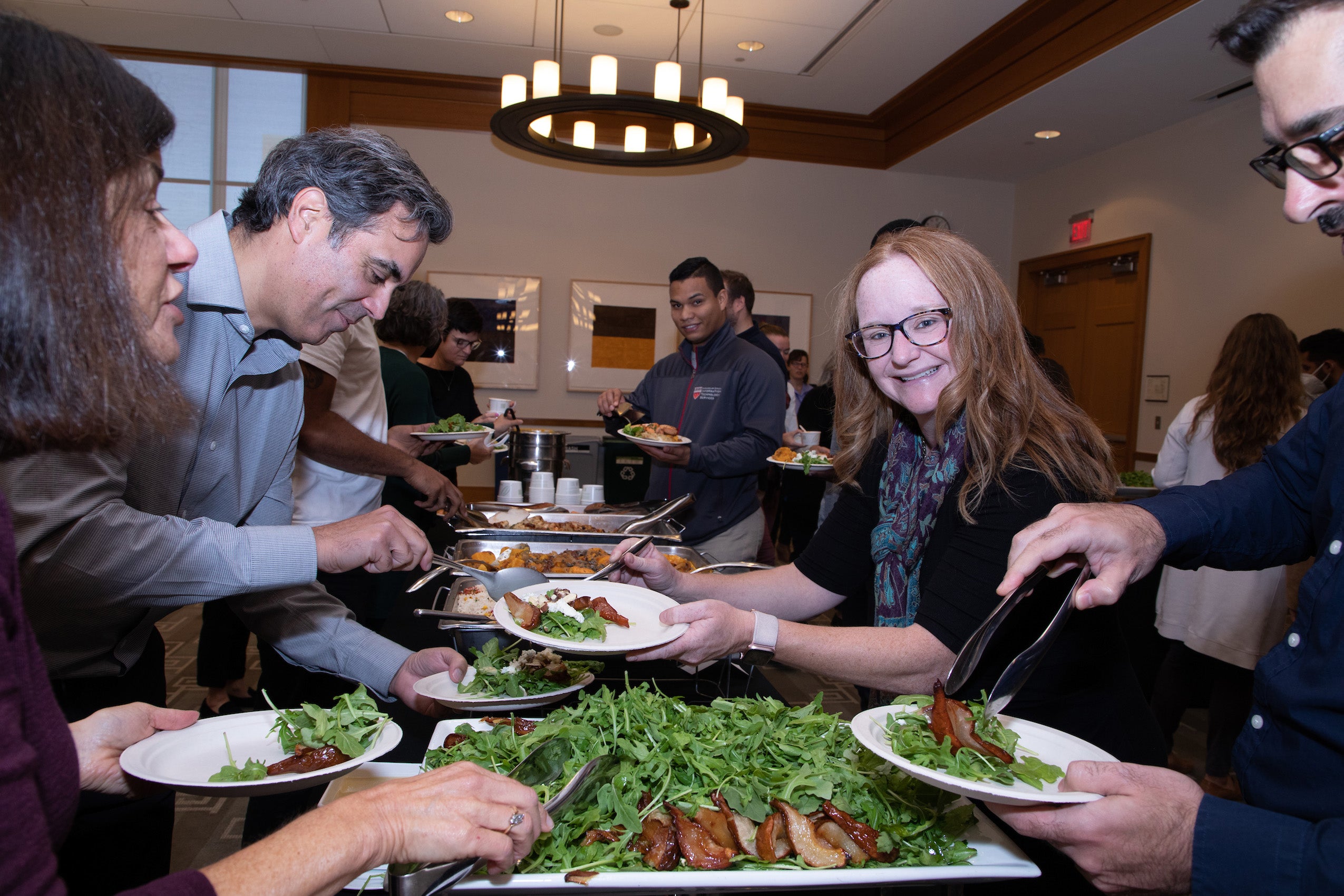 Individuals get food at a buffet