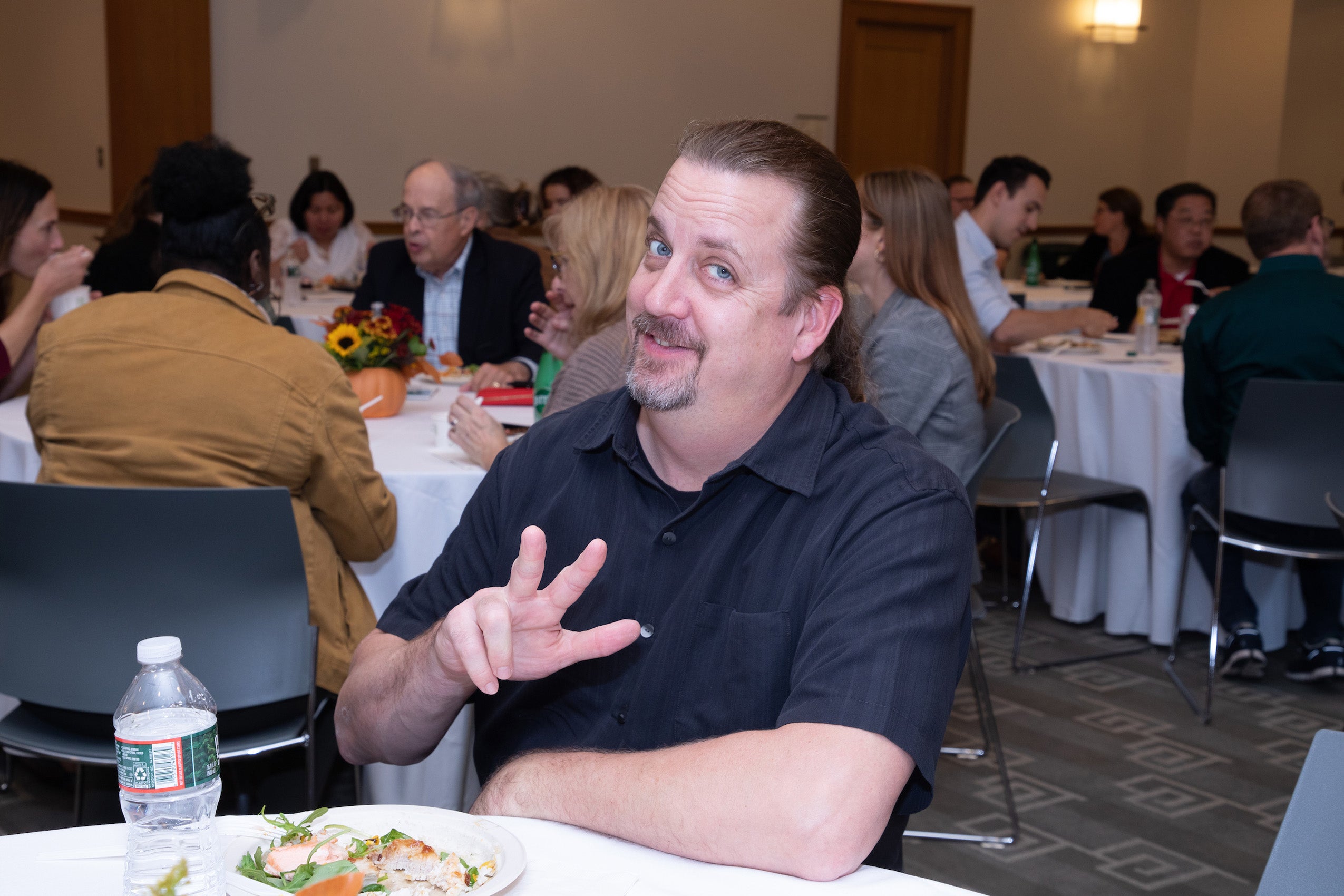 A man sitting at at table smiles for the camera