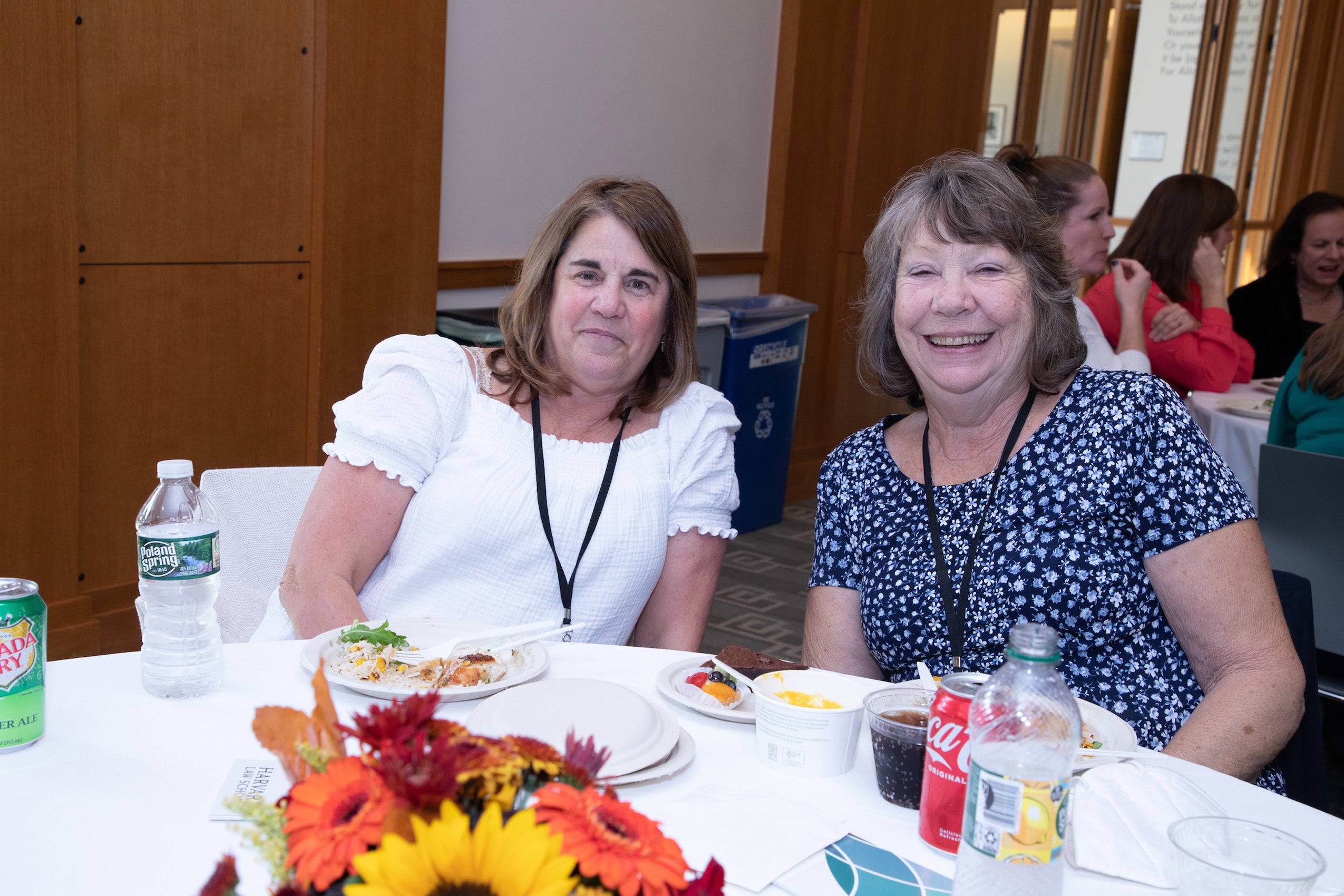 Two women sitting at a table smile for the camera