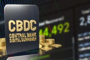 A composite illustration of coins and a digital display of numbers behind a tablet that reads CBDC Central Bank Digital Currency.