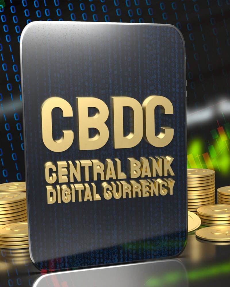 A composite illustration of coins and a digital display of numbers behind a tablet that reads CBDC Central Bank Digital Currency.