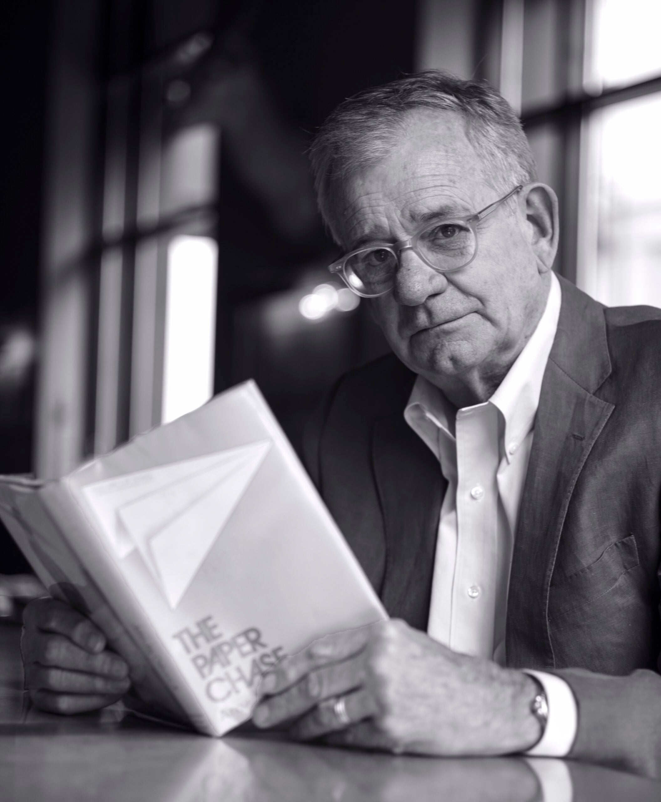 Portrait of John Jay Osborn holding a copy of his book