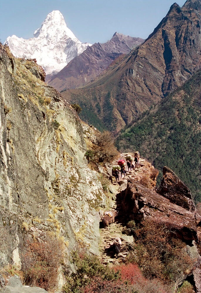 People walking on a trail in high mountains