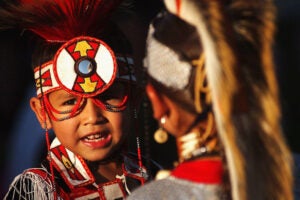 A young Native American boy in dance regalia.