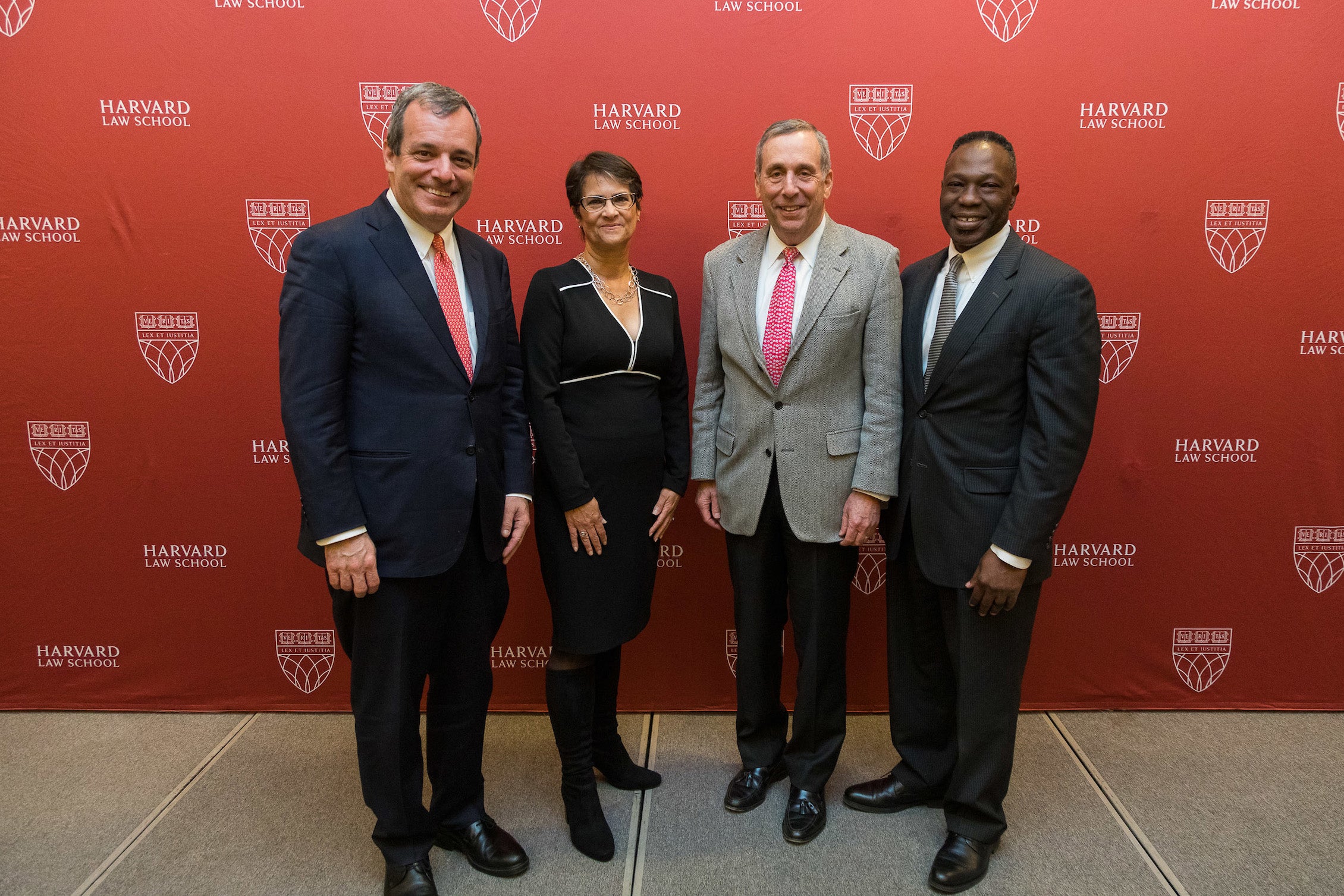 Dean John F. Manning, Martha S. Jones, Larry Bacow, and Guy-Uriel Charles posing for a photo.