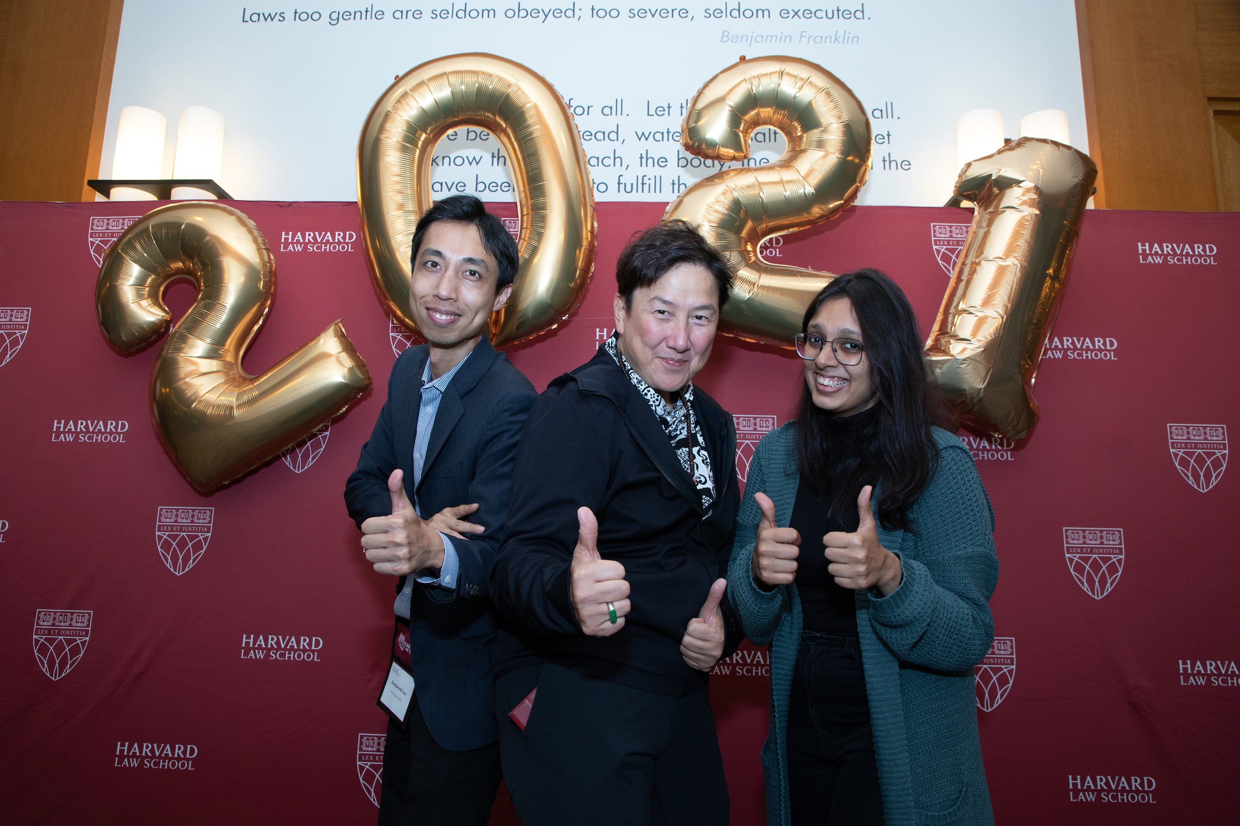 Three people in front of a 2021 balloons giving a thumbs up