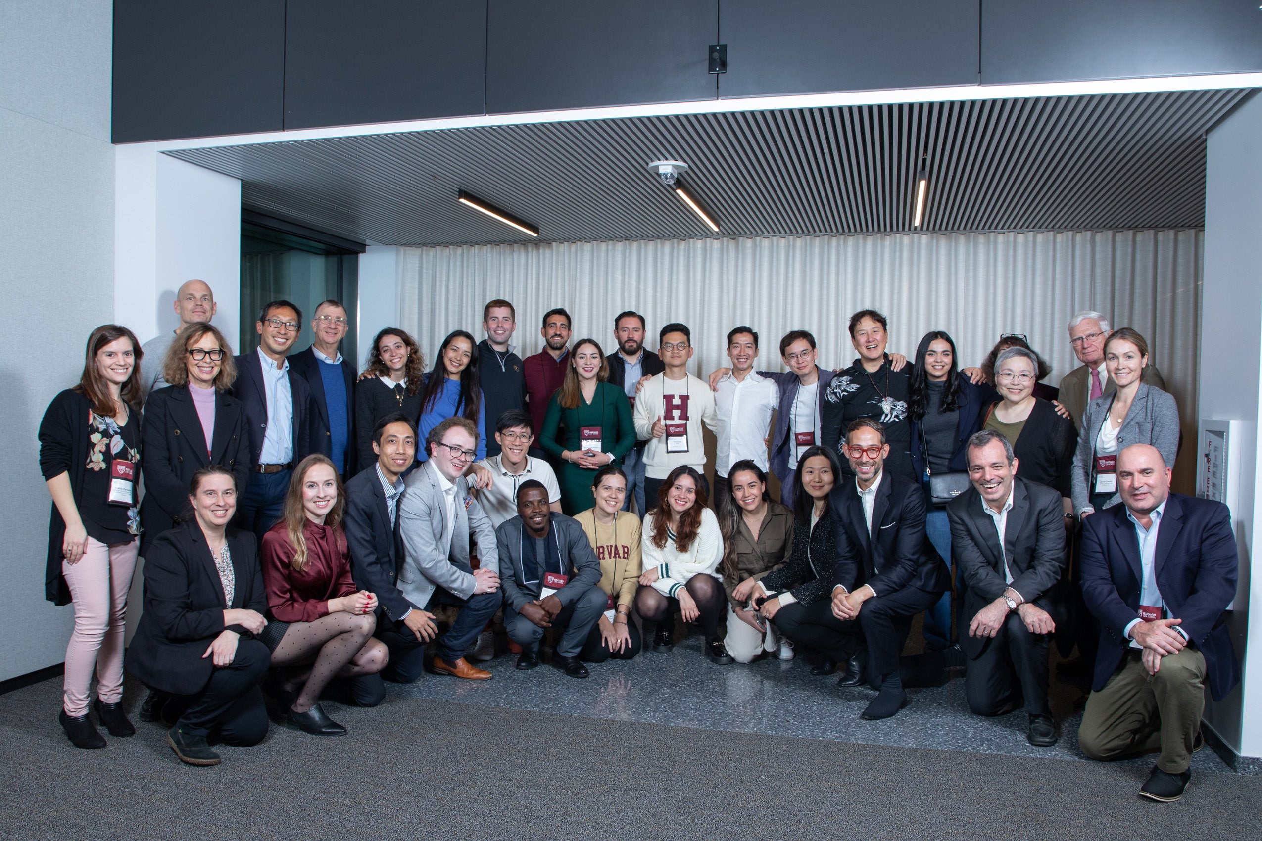 A large group of students, faculty and the dean pose for a group photo