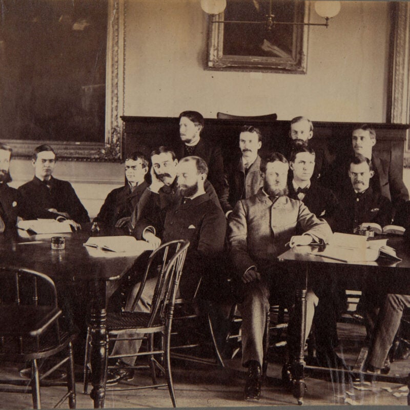 Students on two tables sit in a classroom in Dane Hall
