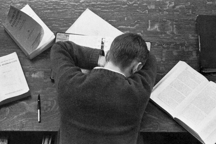 Student asleep on his books in the library
