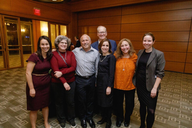 Seven people pose for the camera in a room