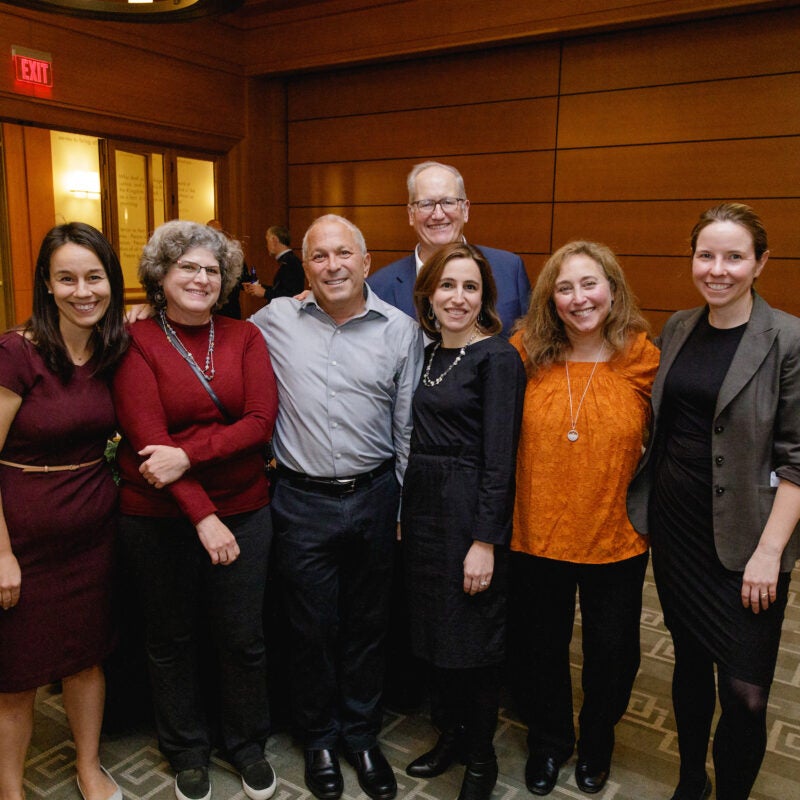 Seven people pose for the camera in a room