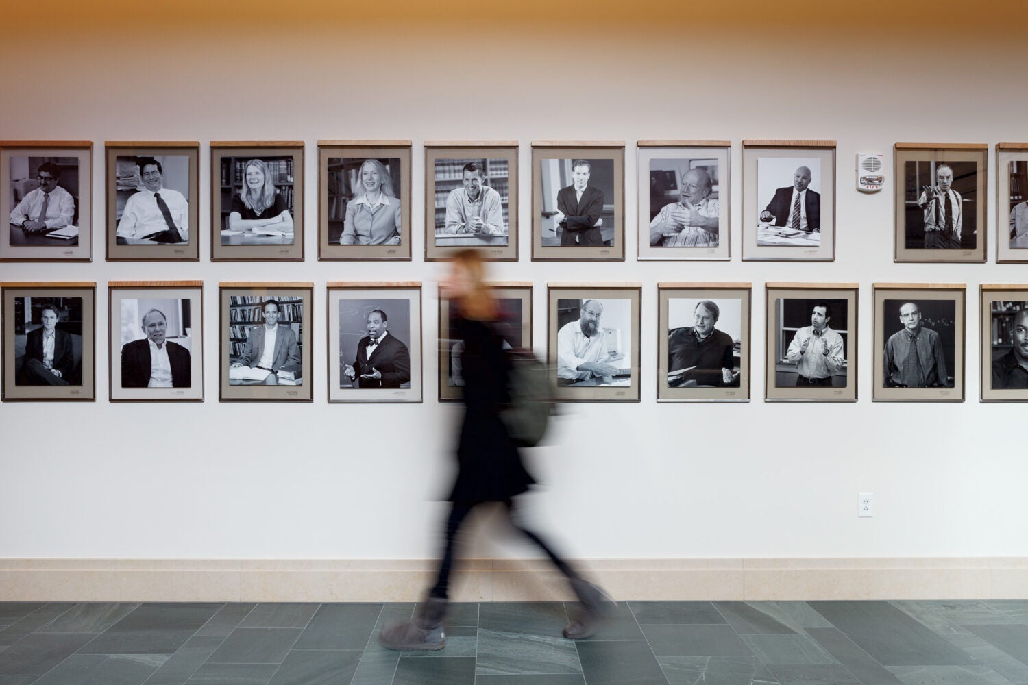Student walks past photos in hallway