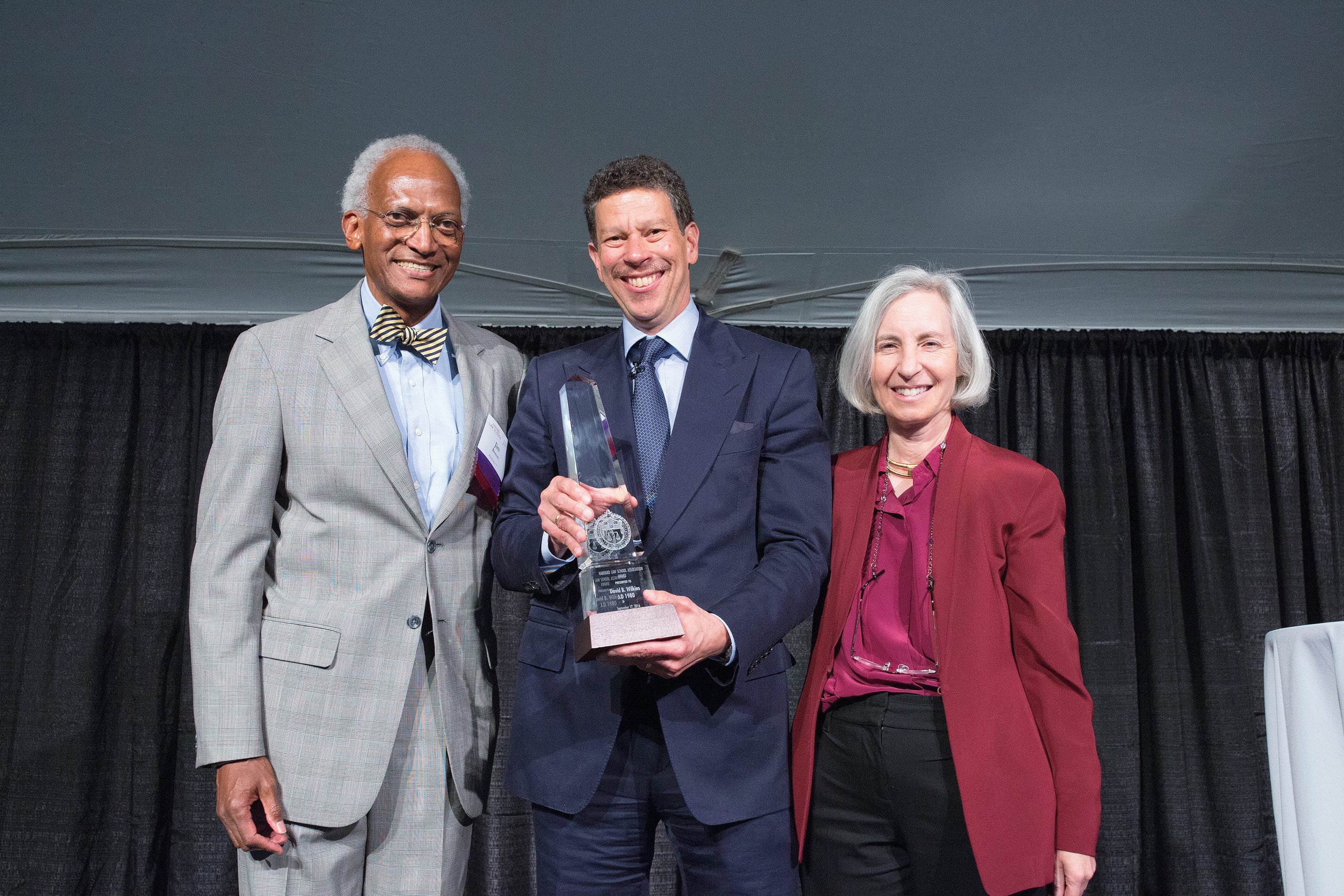 HLS Professor David Wilkins ’80 with the HLSA Award, presented by HLSA Vice President James E. Bowers ’70 and Dean Martha Minow