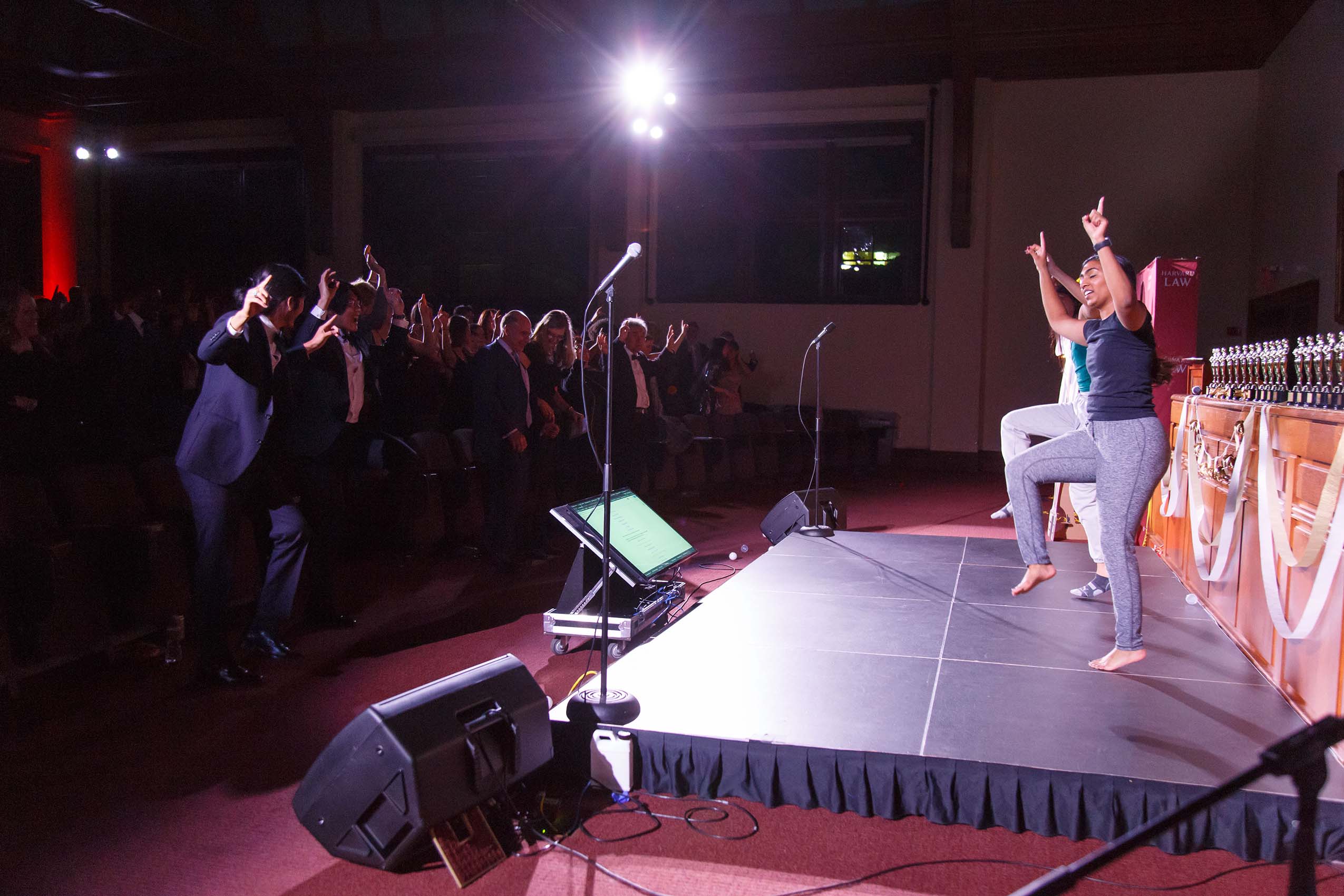Two women dancing on a stage, the audience dancing with them.