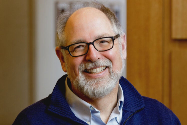 A man, Andrew Mergen, in a dark blue sweater.