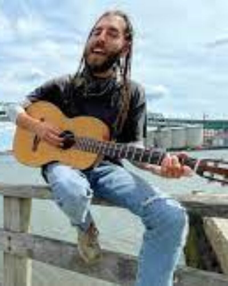 Man playing guitar near a river