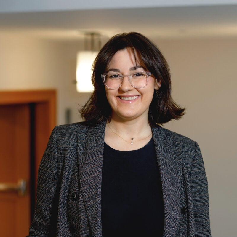 Portrait of Janna Adelstein wearing a grey blazer.