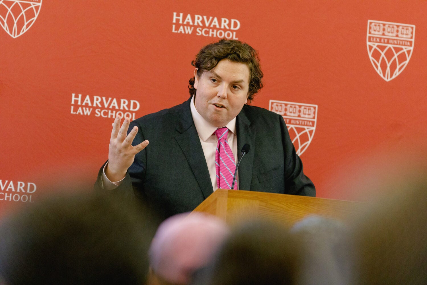 William Baude speaks to the audience from a podium.