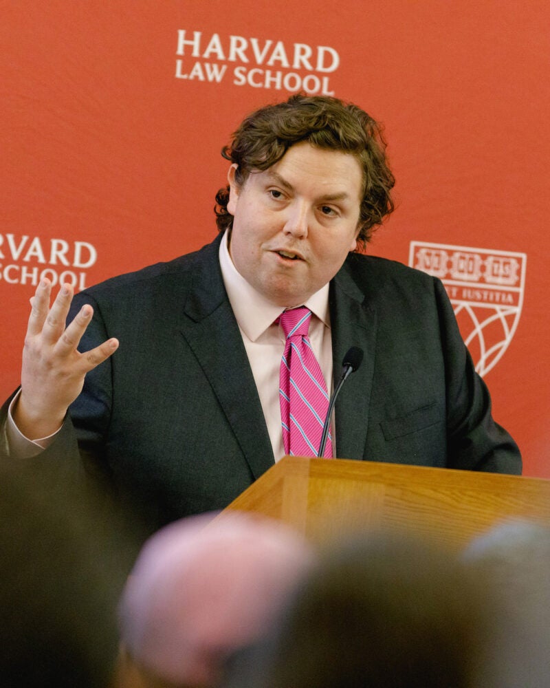 William Baude speaks to the audience from a podium.