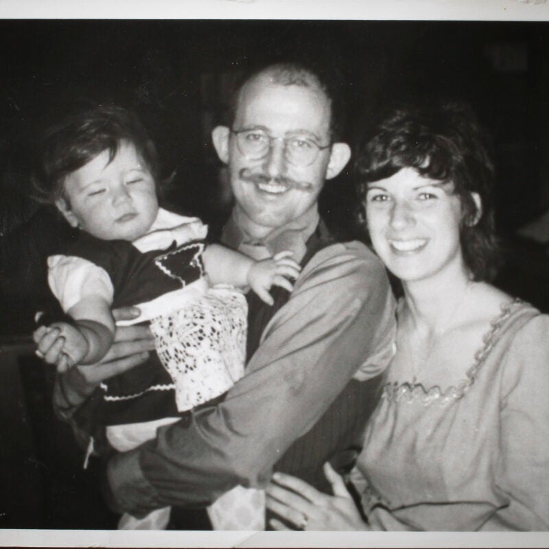 A black and white photo of a man and woman holding child