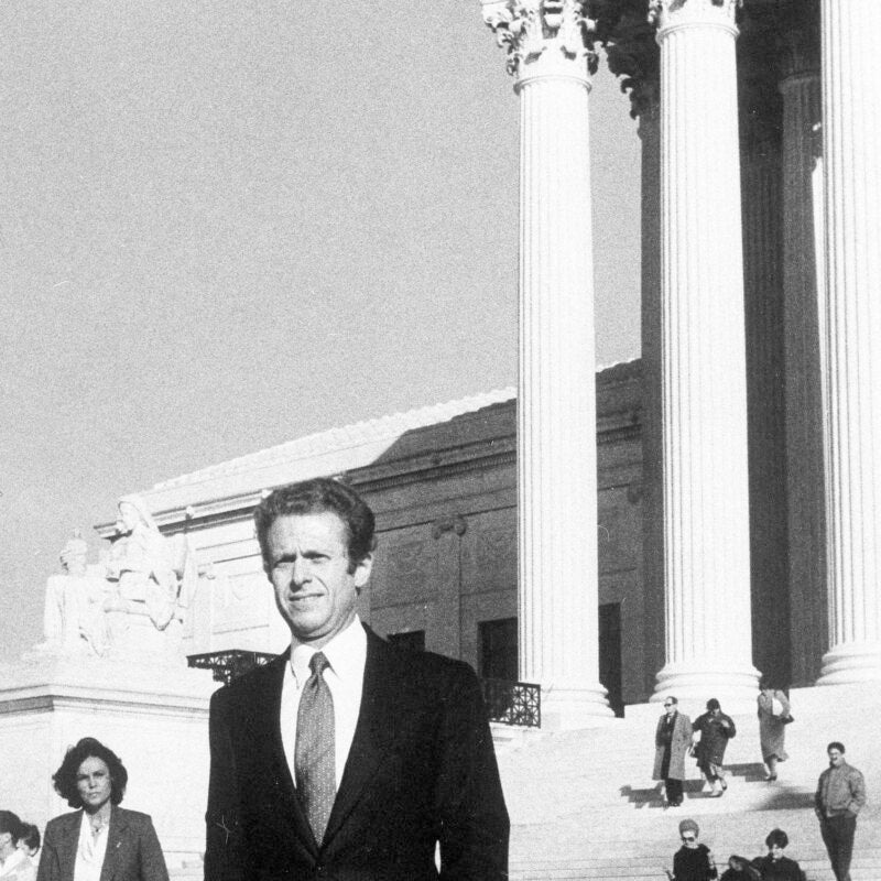 A black and white photo of a man in front of the U.S. Supreme Court