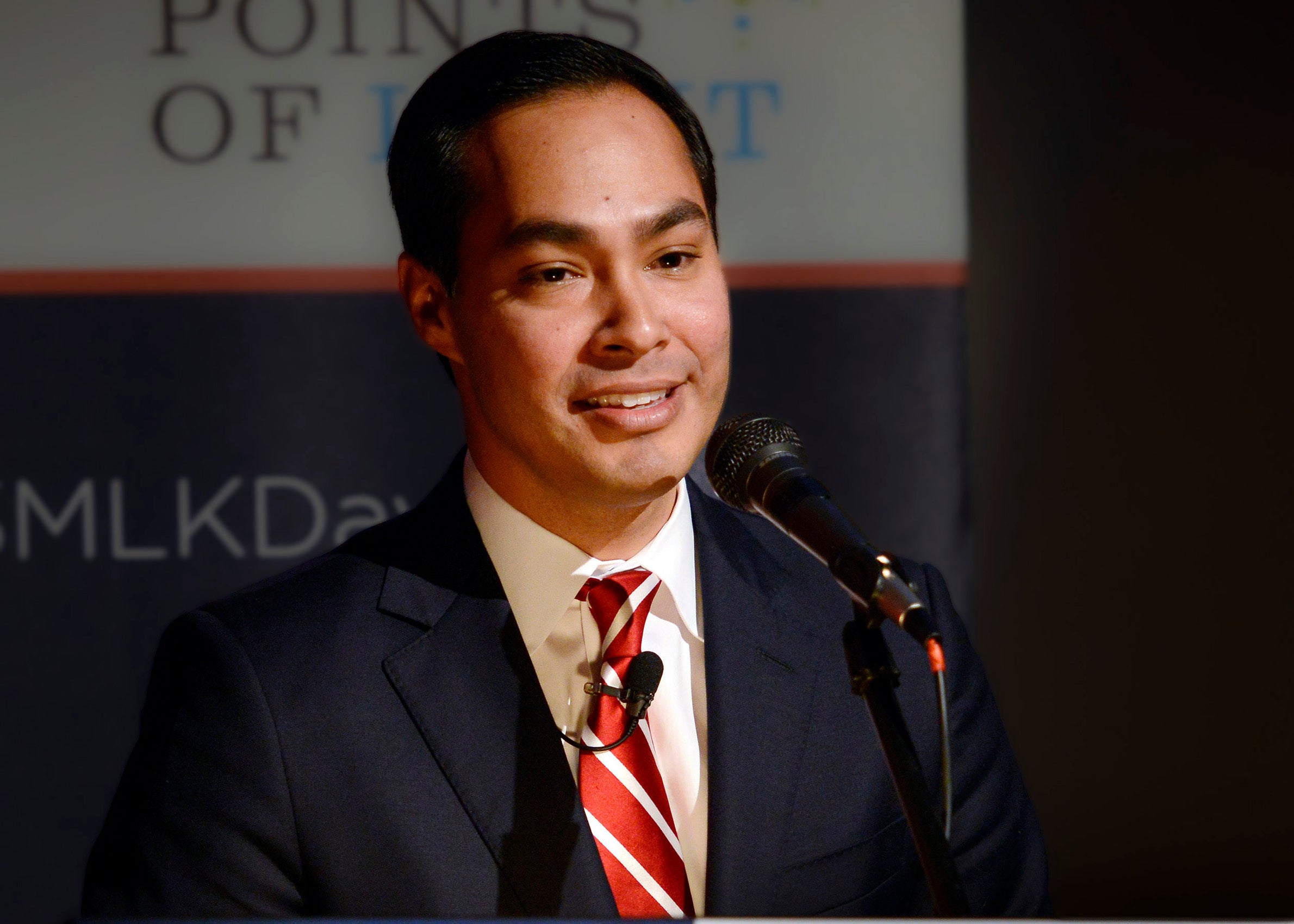 A man wearing a tie and a blue suit at a podium